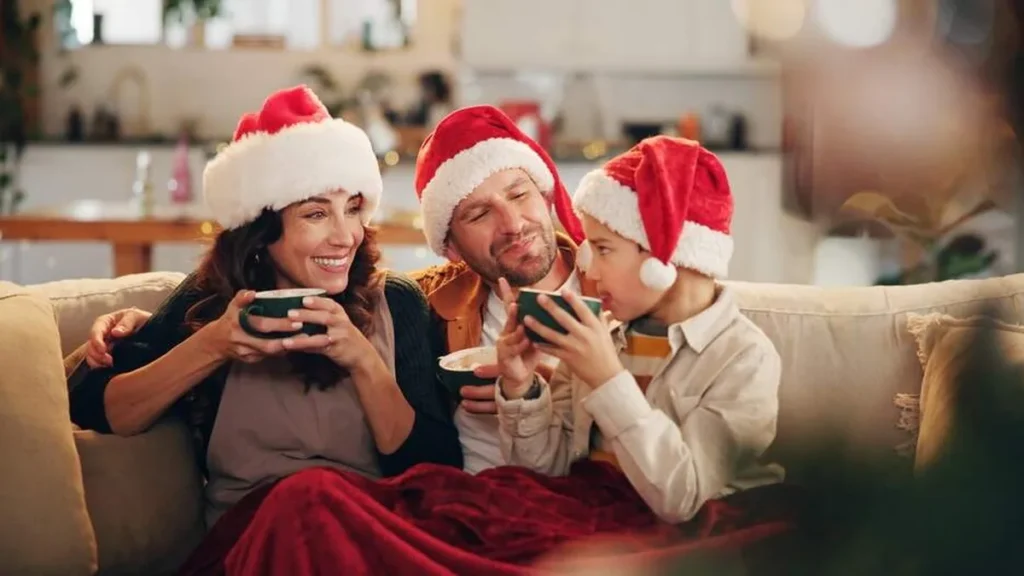 Imagem familia sentada no sofa com touca de natal na cabeca do artigo Dicas para tornar o Advento um tempo de reconexão familiar