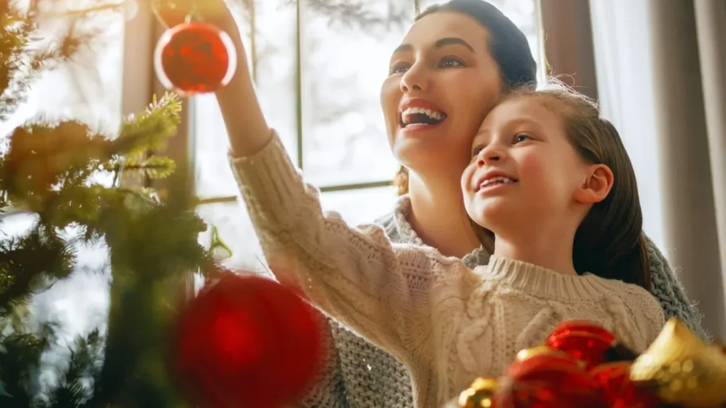 Imagem mae e filha ao lado de arvore de Natal sorrindo. do artigo Uma jornada Interior: Como aproveitar o advento para reavaliar nossas prioridades