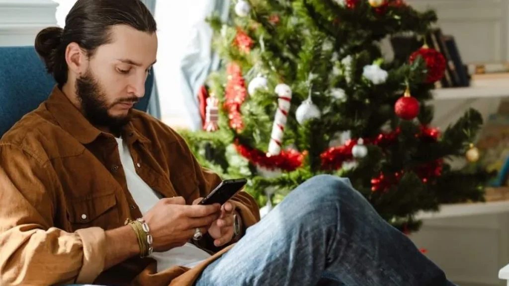 Imagem Homem mexendo no celular no natal do artigo Como viver o Natal em tempos de redes sociais?