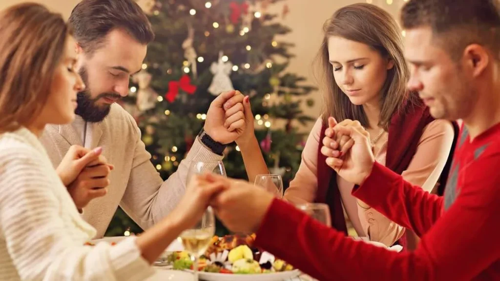 Imagem Familia rezando de maos dadas na ceia de natal do artigo Redescobrindo a alegria do Natal