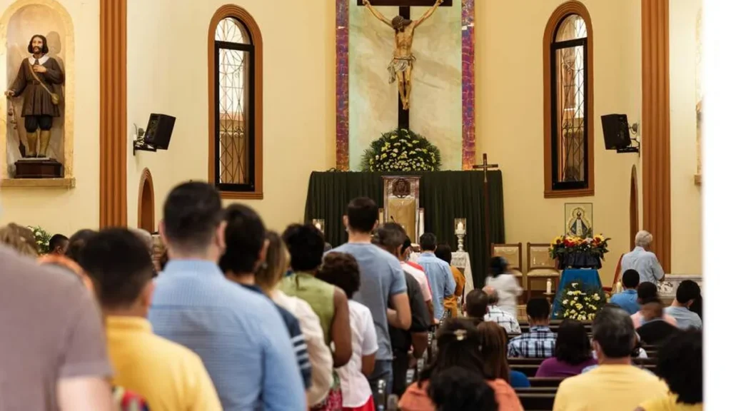 Imagem Pessoas rezando na Igreja Catolica do artigo Por que é fundamental viver a fé em comunidade?
