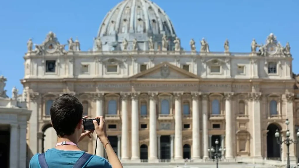 Imagem jovem tira foto da basilica de sao pedro do artigo Vaticano traz destaques do Jubileu do Mundo das Comunicações