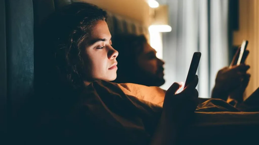 Imagem pessoas mexendo no celular na cama do artigo Será que você precisa de um "detox espiritual"?
