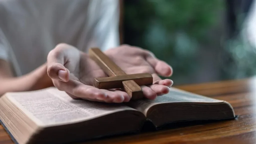 Imagem pessoa rezando com biblia e terco do artigo Oração de louvor