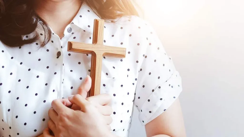 Imagem mulher segurando cruz do artigo Seja cristão de verdade e tenha uma vida coerente