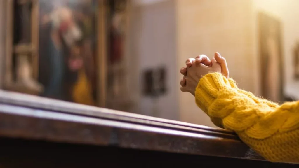 Imagem rezando na igreja do artigo Sinais de que sua fé pode estar mais ligada às emoções