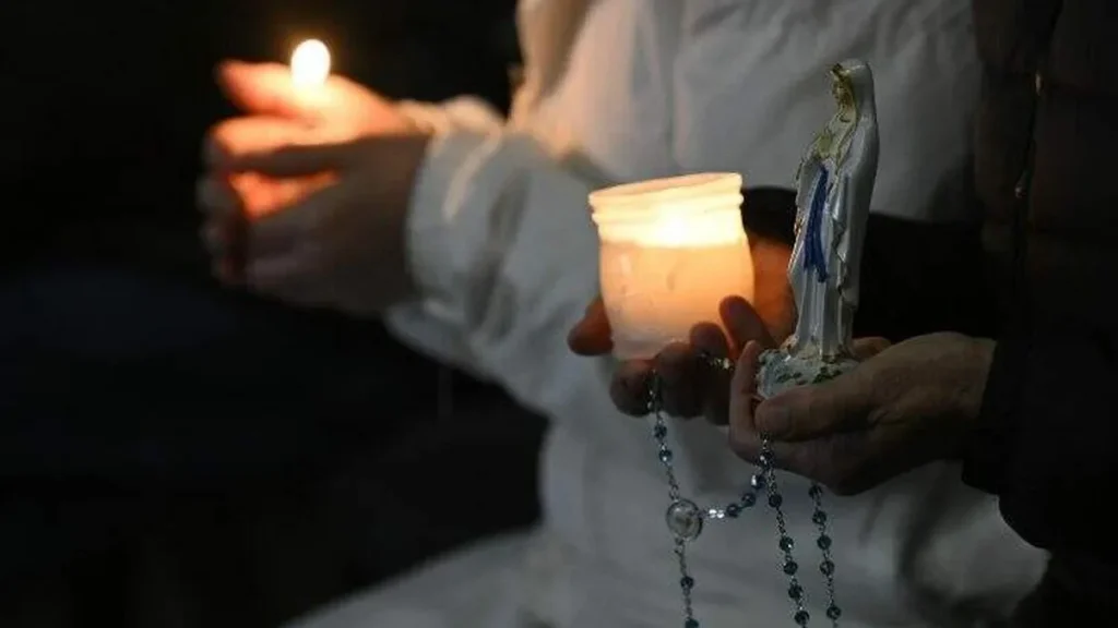 Imagem pessoas seguram velas terco e uma imagem de nossa senhora do artigo Papa Francisco: "Nada nos impede de amar e rezar"