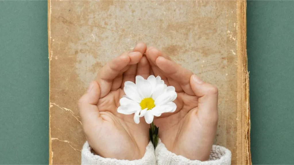 Imagem Mulher segurando uma flor do artigo Dia Mundial da Poesia: músicas que encantam e inspiram