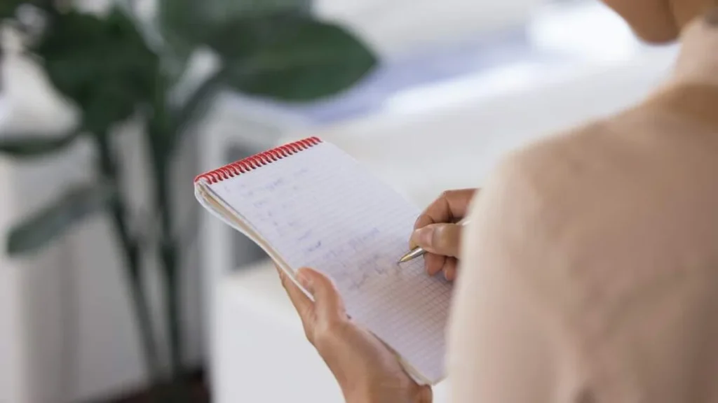 Imagem mulher escrevendo lista do artigo 'A Lista da Minha Vida' de católico