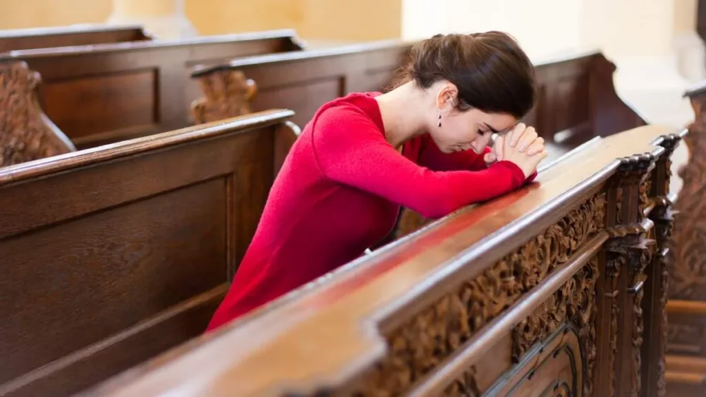 Imagem mulher rezando na igreja do artigo Deus está sempre ao seu lado! Renove sua fé com esperança