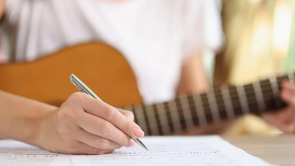 Imagem moca compoe musicas com violao do artigo Participe do edital para criar o hino e letra da Campanha da Fraternidade 2026!