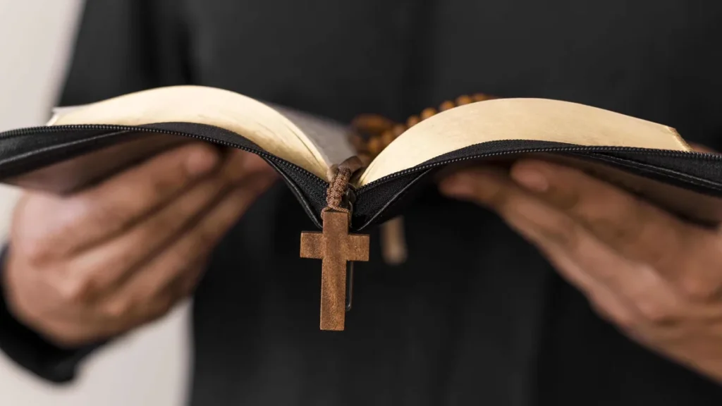 Imagem vista frontal de pessoa com biblia e terco na mao do artigo Portal A12: conteúdos para formação pastoral e catequese