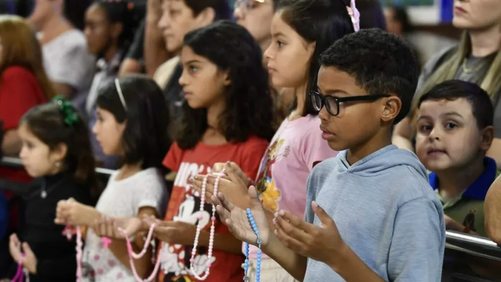 Imagem Criancas rezando o terco do artigo Das crianças envolvidas na Missa à Missa que envolva as crianças