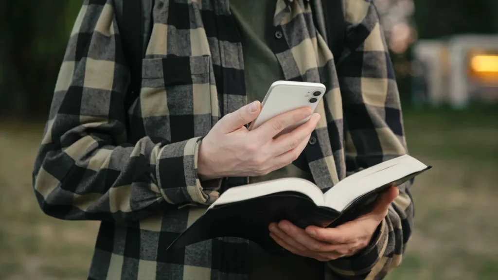 Imagem homem segura biblia e celular do artigo Como comunicar a fé com verdade no mundo digital?