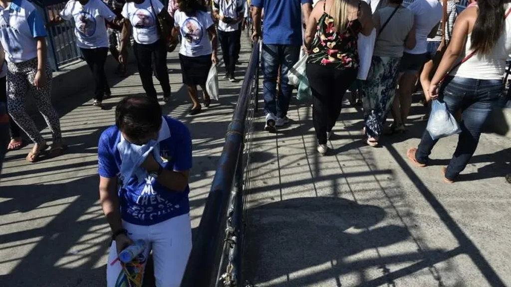 Devota pagando promessa na Passarela da Fé no dia 12 de outubro