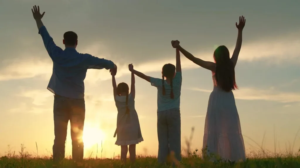 Imagem familia olha para o sol erguendo os bracos felizes do artigo Em Deus está a alegria que transforma o caminhar do seu dia!