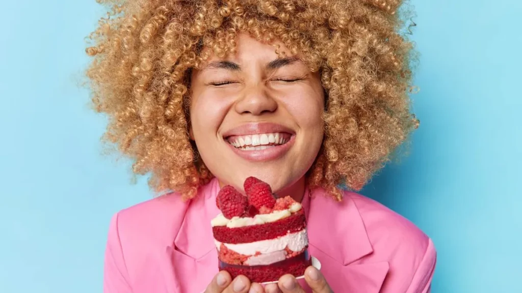 Imagem Mulher feliz em comer um doce do artigo Mudança alimentar: mais equilíbrio, menos restrição