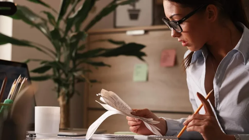 Imagem Mulher fazendo conta para pagar os boletos do artigo Golpes digitais: como não ser vítima do boleto falso?