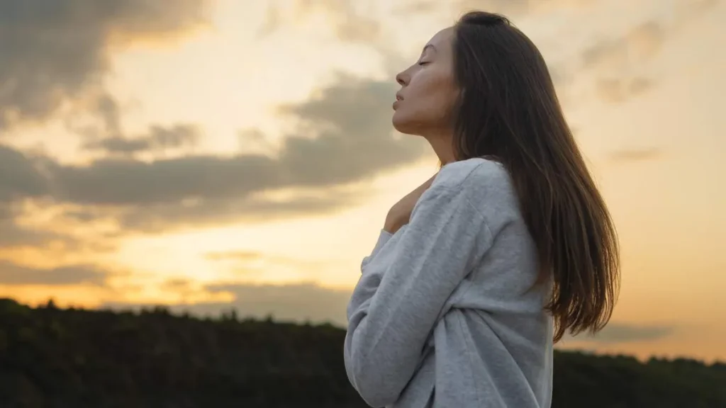 Imagem Mulher em um momento de espiritualidade junto a natureza do artigo Como a fé pode fortalecer a mente e o coração?