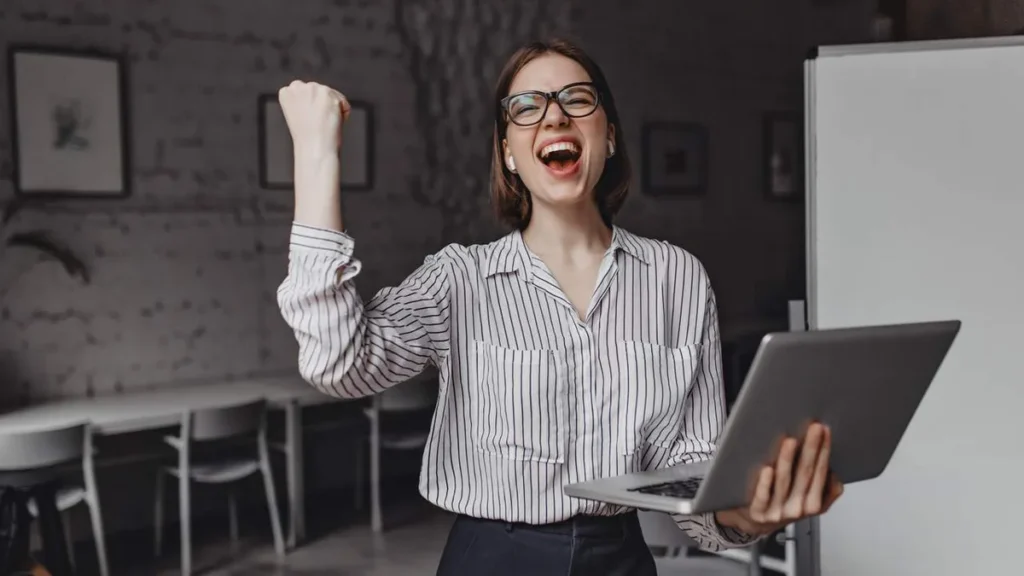 Imagem Mulher feliz porque alcancou uma promocao profissional do artigo Como enfrentar decisões difíceis e avançar na carreira