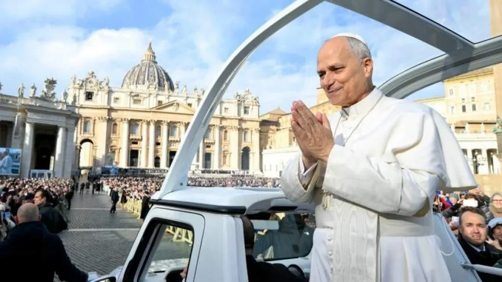Imagem papa leao xiv no papamovel com as maos postas sorrindo cumprimentando fieis na praca sao pedro em 2025 do artigo Papa Leão XIV pede coragem para confiar na vida
