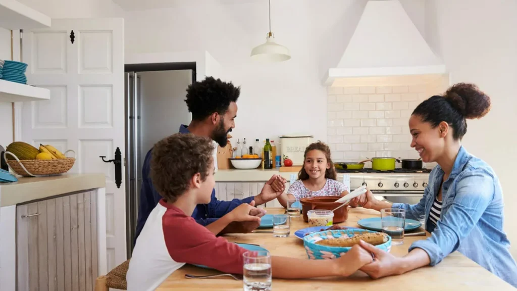 Imagem familia rezando na cozinha do artigo Catequese: a família como primeiro lugar da iniciação cristã