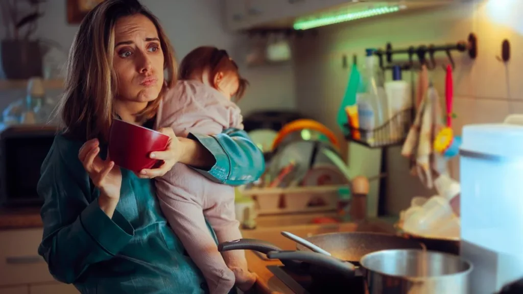 Imagem mae com crianca no colo e um copo de cafe estressante do artigo Quando as férias não são para todos: o peso invisível da maternidade