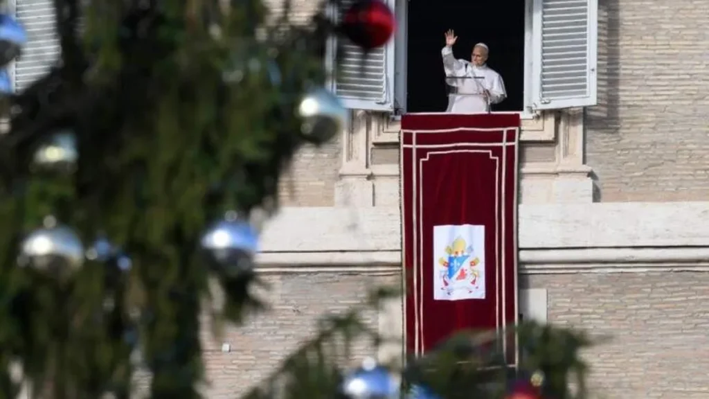 Imagem papa leao xiv em angelus na janela e com arvore de natal no plano esquerdo em 2025 do artigo Papa Leão XIV pede um Natal com menos consumo e mais presença