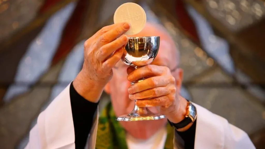 Imagem padre levantando a hostia durante missa do artigo Reflexão Semanal: João Batista anuncia o “Cordeiro de Deus”