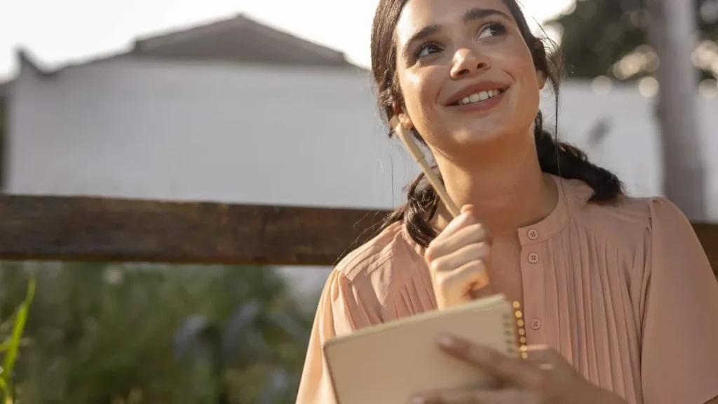 Imagem Mulher sorrindo e listando as novas metas de ano novo do artigo Organização e Planejamento para o bem-estar emocional