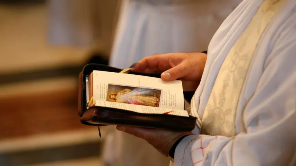 Imagem Maos de um padre com a Biblia aberta do artigo Veja a mensagem para o 30º Dia da Vida Consagrada