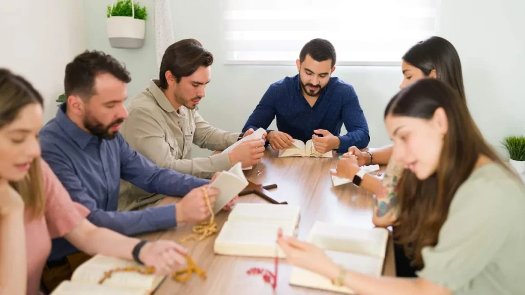 Imagem reuniao pastoral pessoas na mesa rezando do artigo Saiba como realizar uma reunião de pastoral em 5 passos