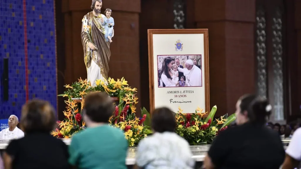 Imagem Imagem de sao jose no altar central e fieis de costas rezando do artigo No dia de São José, Igreja reza pela família e pela paz