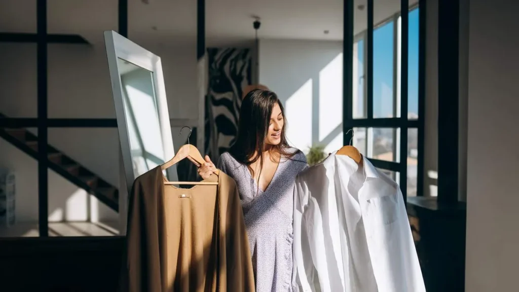 Imagem Mulher escolhendo uma roupa do artigo Como a forma de se vestir influencia a autoestima feminina?