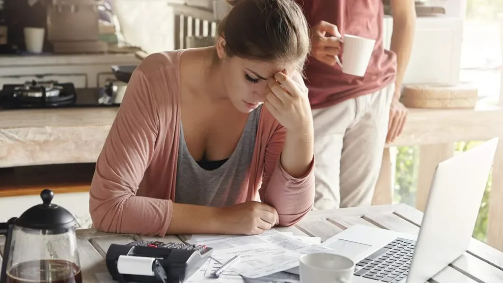 Imagem Mulher preocupada calculando suas dividas do artigo Cobrança de dívidas: limites e direitos do consumidor