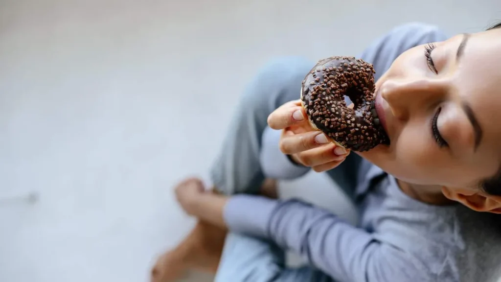 Imagem Mulher comendo doce do artigo Resistência à insulina: o inimigo silencioso da perda de peso