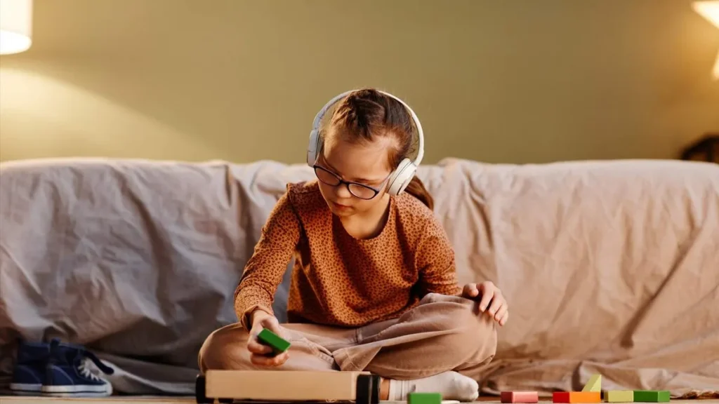 Imagem crianca autista brinca com objetos no chao de um quarto do artigo Livro sobre autismo propõe novo olhar terapêutico