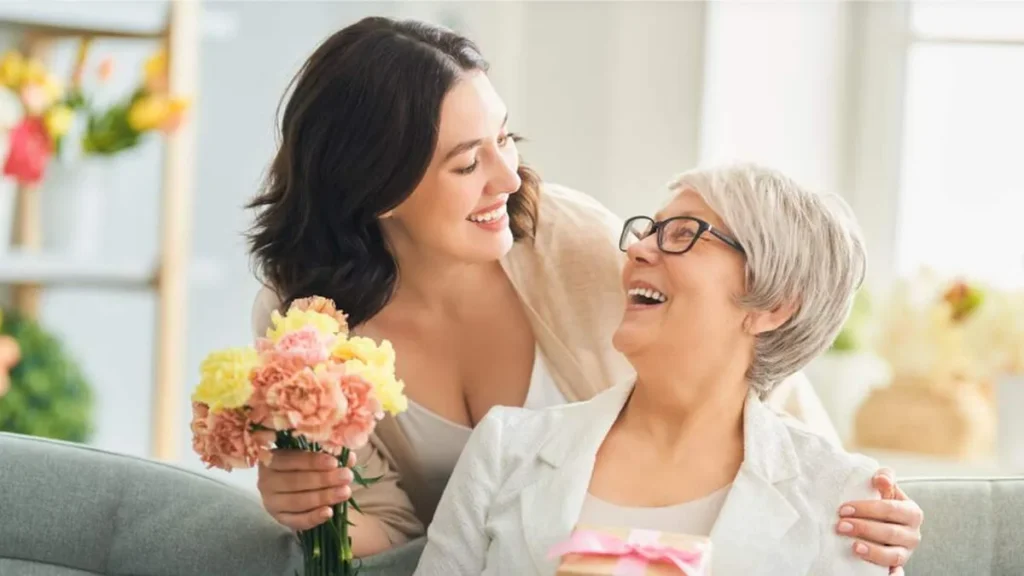 Imagem Filha dando flores a mae pelo Dia das maes do artigo Almanaque Especial Dia das Mães: memórias, amor e legados